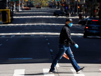 Un hombre, con mascarilla, camina por una de las avenidas de Nueva York.