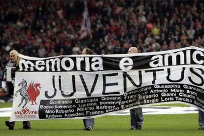 Aficionados del Juventus y Liverpool portan una pancarta en la que se lee "Memoria y amistad" y el nombre de los fallecidos en Heysel en 1985.