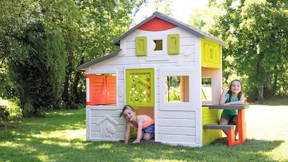 Casita de jardín en la que están jugando dos niñas.