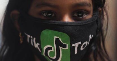 Una joven india con una mascarilla con el logo de TikTok.