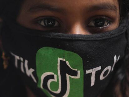 Una joven india con una mascarilla con el logo de TikTok.