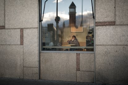 Una joven desayuna en el interior de un bar en plaza España de Barcelona.