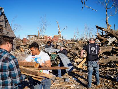 People clean up debris after a devastating outbreak of tornadoes ripped through several U.S. states, in Mayfield, Kentucky, U.S., December 12, 2021. REUTERS/Cheney Orr