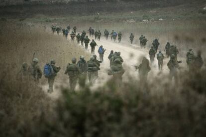 Soldados israelíes caminan por una carretera hacia el Líbano desde la frontera norte de Israel.
