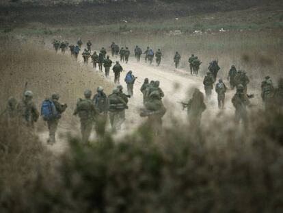 Soldados israelíes caminan por una carretera hacia el Líbano desde la frontera norte de Israel.