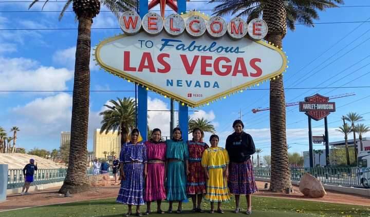 Verónica Palma con otras corredoras rarámuri delante del cartel de Las Vegas durante The Speed Project en abril de 2024.