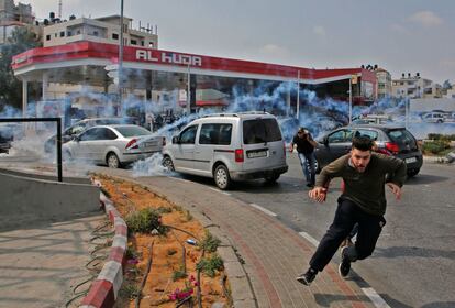 Manifestantes palestinos huyen del gas lacrimógenon lanzado por las fuerzas israelíes, en Ramala.