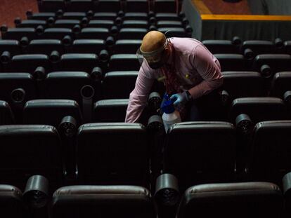 Un empleado limpia los asientos de una sala de un cine, el miércoles en Caracas.