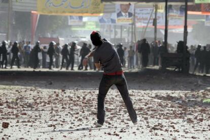 Un joven cristiano arroja piedras a las fuerzas de seguridad durante una revuelta en El Cairo tras la paralización de las obras de una iglesia.