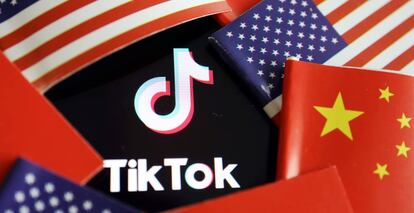 Logotipo de TikTok entre banderas de China y EE UU.