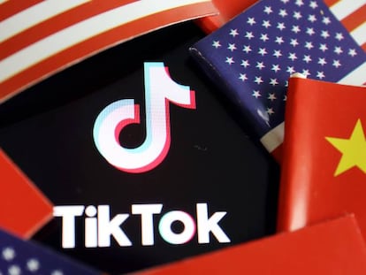 Logotipo de TikTok entre banderas de China y EE UU.