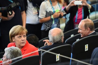 La canciller alemana, Angela Merkel, se sienta al lado del presidente de la FIFA, Joseph Blatter, y el presidente ruso Vladimir Putin (R) antes del partido final de fútbol entre Alemania y Argentina.