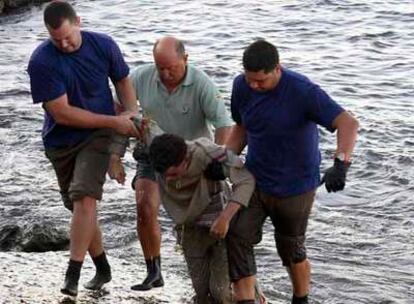 El cadáver de uno de los inmigrantes fallecidos es sacado de las aguas de la playa de Risco Verde.