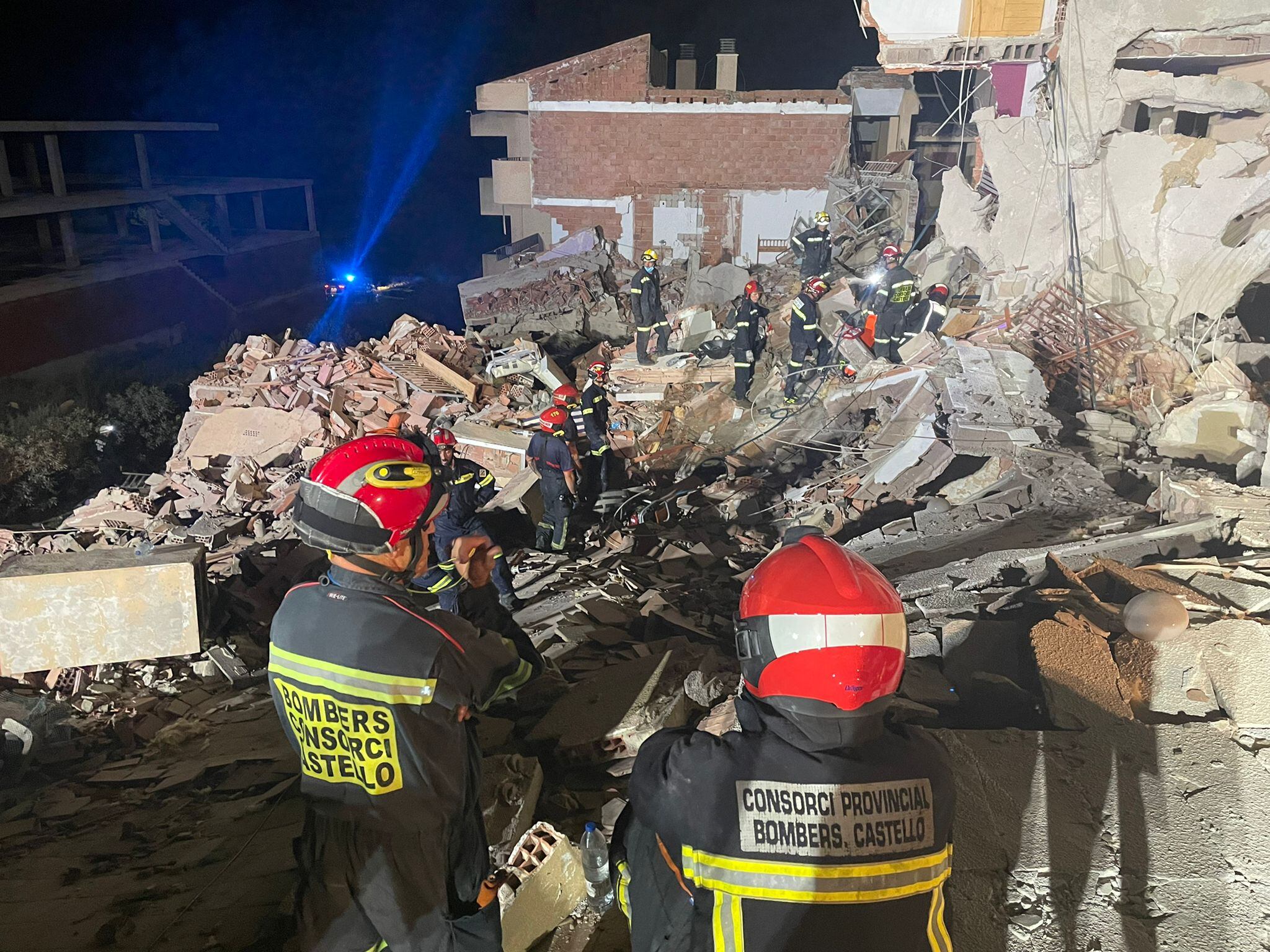 Los bomberos, entre los escombros del edificio.