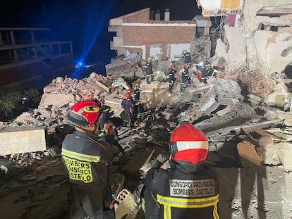 Los bomberos, entre los escombros del edificio.