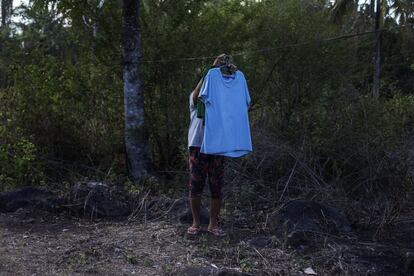 Paliza descuelga la ropa tendida y lavada por encargo de unos vecinos. Vive desde hace 20 años al pie del volcán Mayón, y gana alrededor de 70 euros al mes lavando ropa, vendiendo dulces y cosechando.