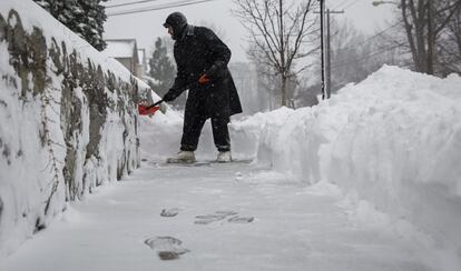 Uu hombre retira nieve en una calle de Washington.