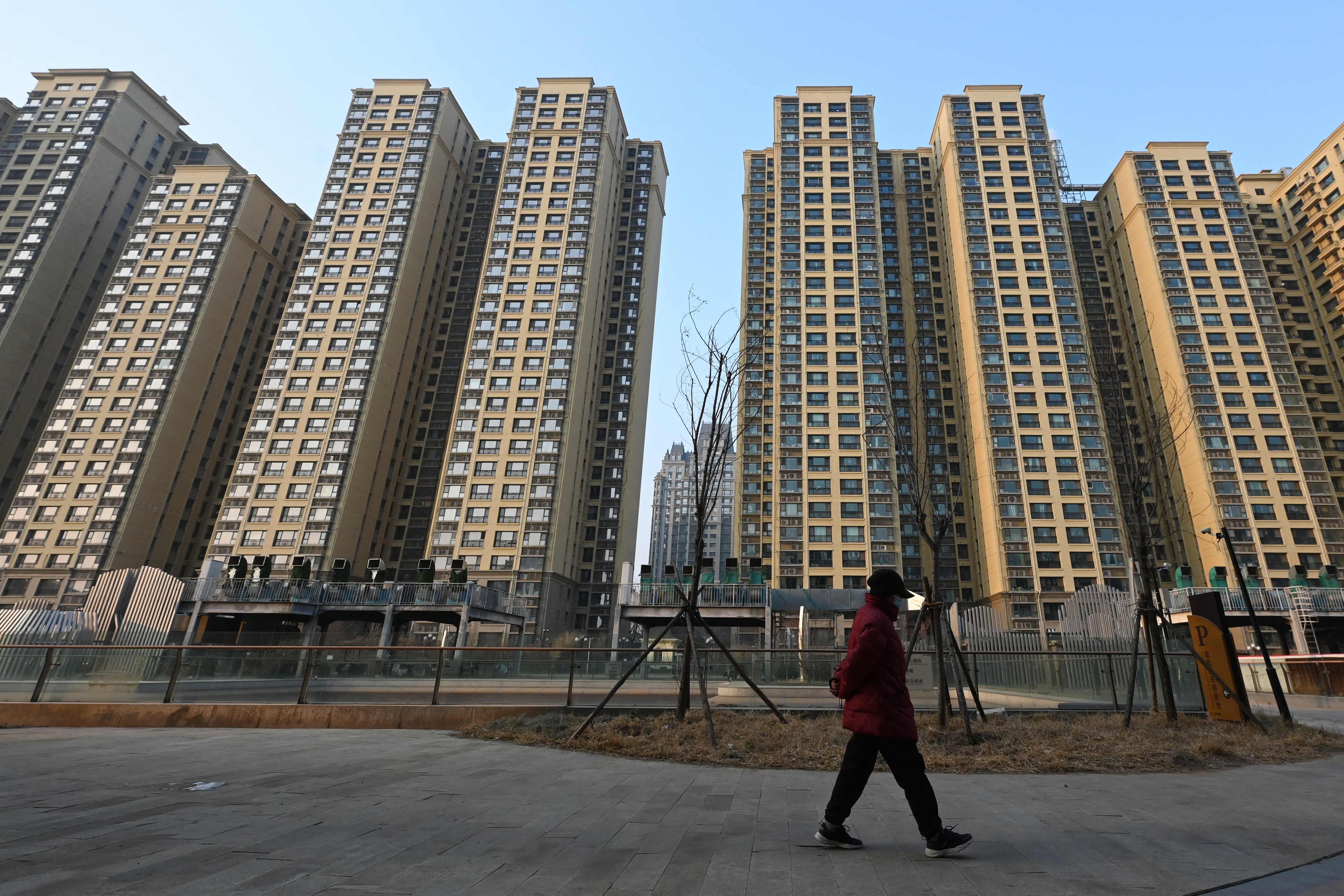 Una persona camina delante de un complejo inmobiliario promovido por Evergrande en Pekín.