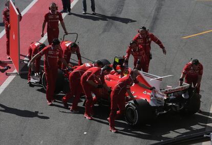 Los mecánicos de Ferrari empujan el coche de Kimi Raikkonen dentro del box durante los entrenamientos de Fórmula 1 en el circuito de Cataluña en Monteló (Barcelona).