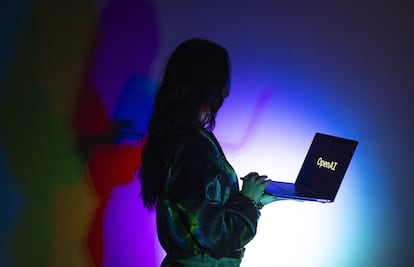 Una mujer mira la pantalla de un ordenador portátil que muestra el logotipo de OpenAI, la empresa creadora de ChatGPT