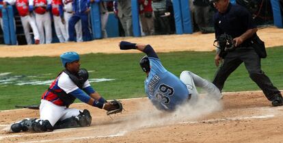 Kevin Kiermaier (d) de Rayos de Tampa Bay se barre a la base ante Cuba.