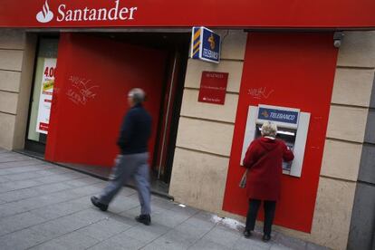 Una mujer utiliza un cajero del Banco Santander en Madrid.