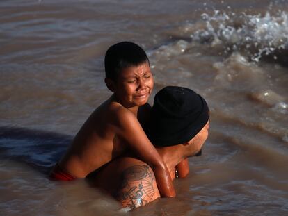 Un migrante con su hijo en la espalda cruza el Río Bravo el 14 de marzo de 2024, en Ciudad Juárez (México).