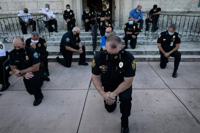 Agentes de policía se arrodillan durante la manifestación en Coral Gables (Florida).