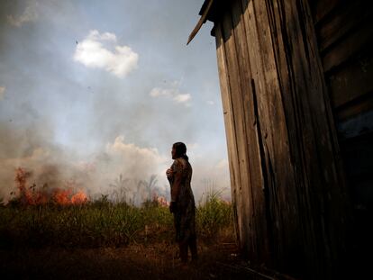 A woman watches as a forest fire approaches her home, in Porto Velho, Brazil, in August of 2020