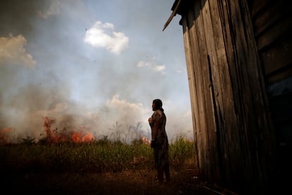 Una mujer observa cómo un incendio forestal se acerca a su vivienda, el Porto Velho
