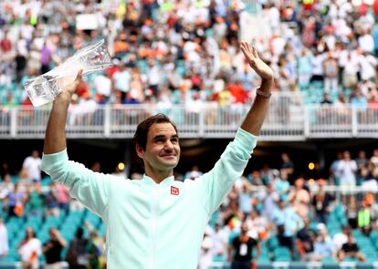 Federer, con su trofeo, saluda a la grada de Miami.