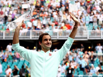 Federer, con su trofeo, saluda a la grada de Miami.