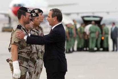 El ministro de Defensa recibe ayer en Torrejón a los cuatro militares heridos en Afganistán.