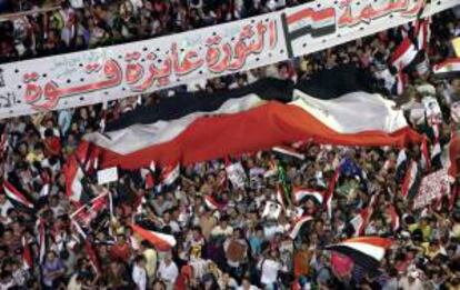 Varias personas ondean este viernes una bandera egipcia, durante una manifestación a favor de las fuerzas armadas en la plaza Tahrir en El Cairo (Egipto).