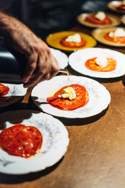 Luke Dolphin, único empleado del restaurante, prepara queso casero con tomates recogidos solo unas horas antes.