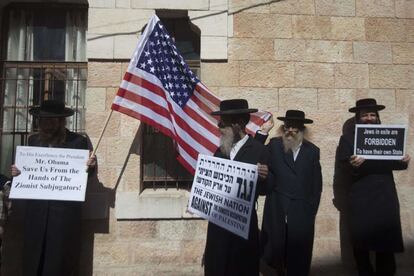 Miembros de Neturei Karta, judíos que rechazan cualquier forma de sionismo, por lo que se oponen a la existencia del Estado de Israel, sostienen pancartas y una bandera de EE.UU. en una calle de Jerusalén (Israel).