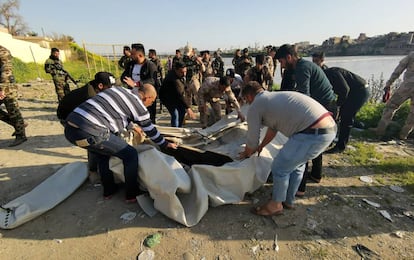 Varias personas ayudan en el rescate junto al río Tigris en Bagdad (Iraq).