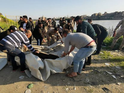 Varias personas ayudan en el rescate junto al río Tigris en Bagdad (Iraq).