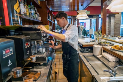 Un camarero prepara un café en una cafetería en Teruel.