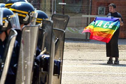 Un manifestante muestra una bandera con la palabra paz en italiano a un grupo de policías, ayer en Annemasse.