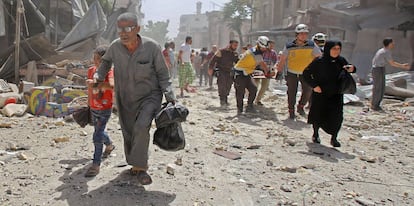 Un grupo de voluntarios de los 'cascos blancos' llevan a un hombre herido en camilla tras un ataque aéreo en la ciudad de Maaret al-Numan, en la provincia de Idlib (Siria).