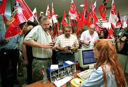 Los dirigentes de CC OO y UGT, Joan Sifre y Rafael Recuenco, muestran sus carnets para acceder al Servef, con los manifestantes a sus espaldas.