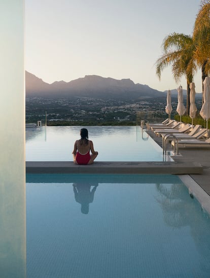 Un mujer mira hacia la sierra de Aitana desde una de las piscinas exteriores del Sha Wellness Clinic, en el municipio de L’Albir (Alicante).