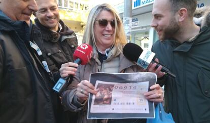 Carmen, vecina del barrio de Quintana (Ciudad Lineal), sujeta una fotocopia del número premiado con el tercer premio.