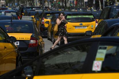 Una peatón toma fotografías mientras los taxistas bloquean la Gran Vía en Barcelona el 27 de julio de 2018 después de una huelga de 48 horas.