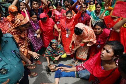 Un trabajador yace herido en el suelo durante los enfrentamientos con la policía en una protesta que exigía la actualización de los pagos retrasados en Daca (Bangladés).