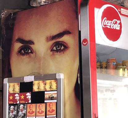 'Souvenirs' con el rostro de Ho Chi Min, apoyados en una máquina de Coca-Cola en Hanói.