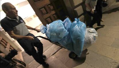 Un trabajador saca del Palau de la Generalitat varias bolsas con documentos triturados,ayer por la noche, durante la reunion del presidente, Carles Puigdemont, con sus Consellers.