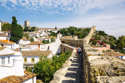 Un senderista camina por el pueblo medieval de Óbidos, parte del recorrido de Palmilhar Portugal, en una imagen cedida por el propio municipio.