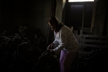 Thérèse Tarabayt stacks firewood at her house in Mayfouq.